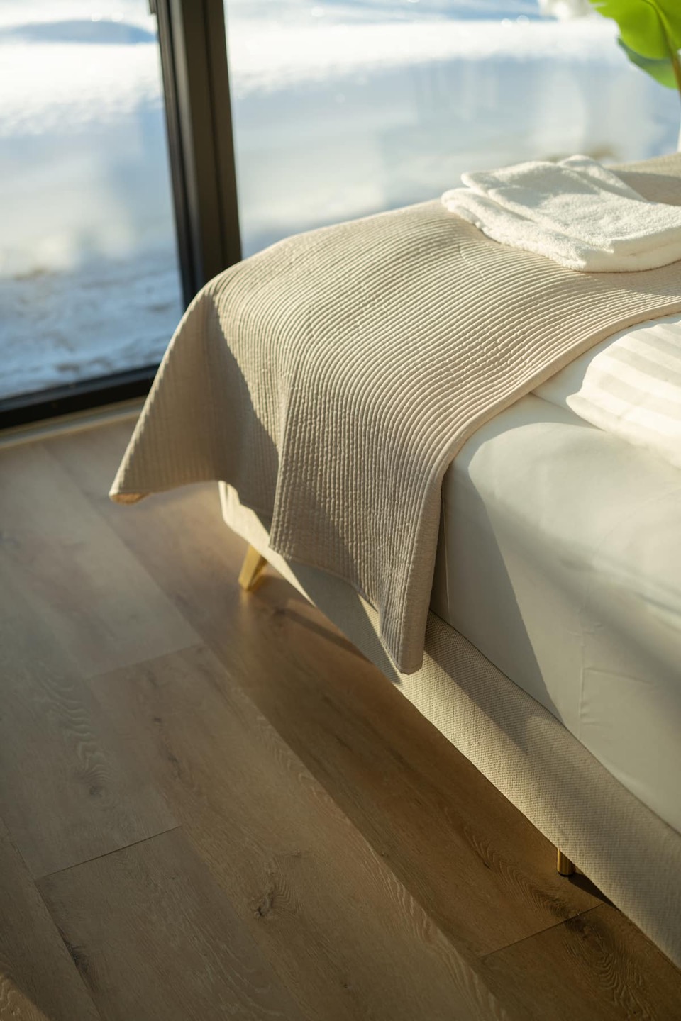 The bed beneath the skylight, morning light falling across the linen