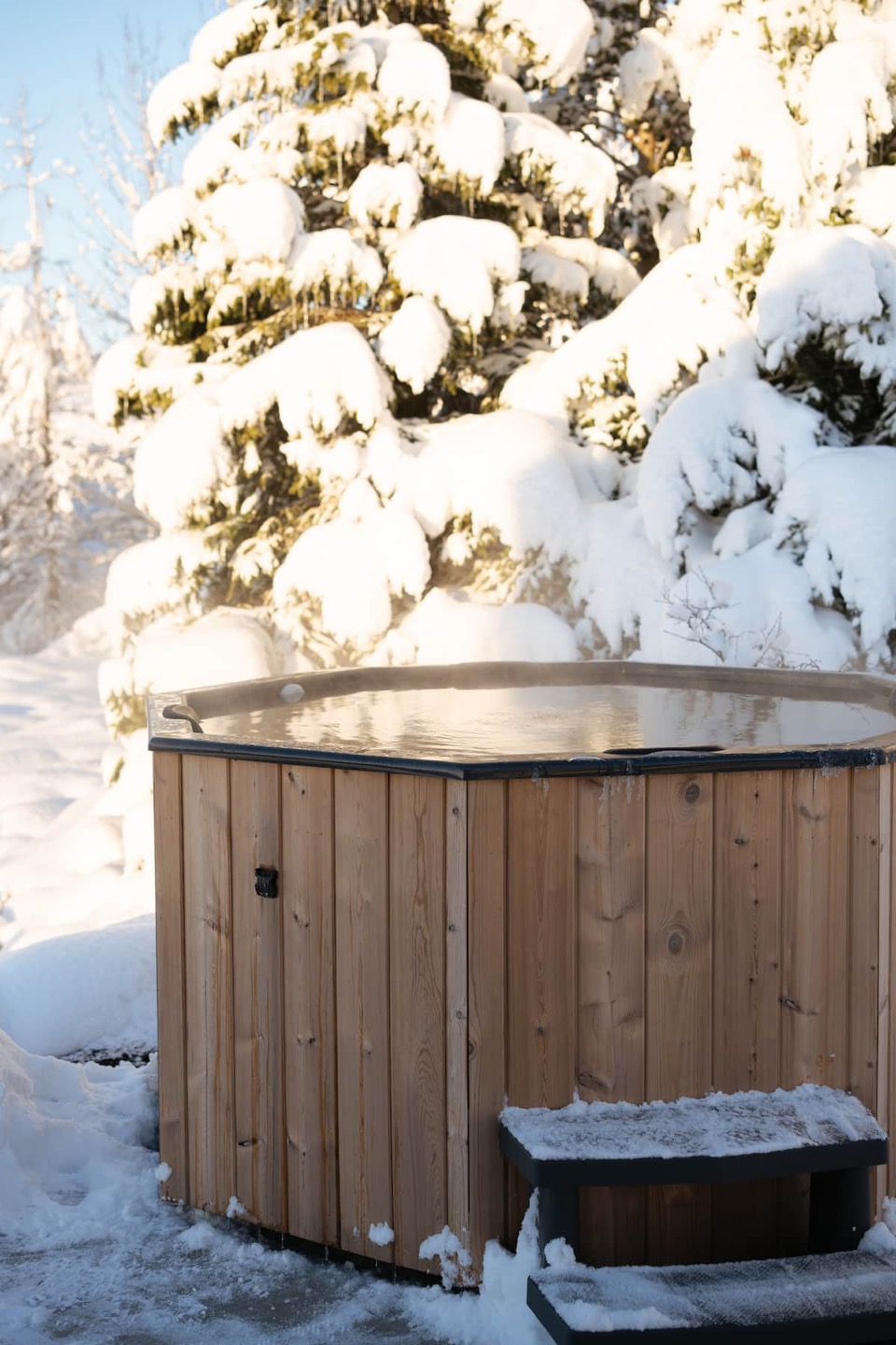 The wooden hot tub steaming in the snow