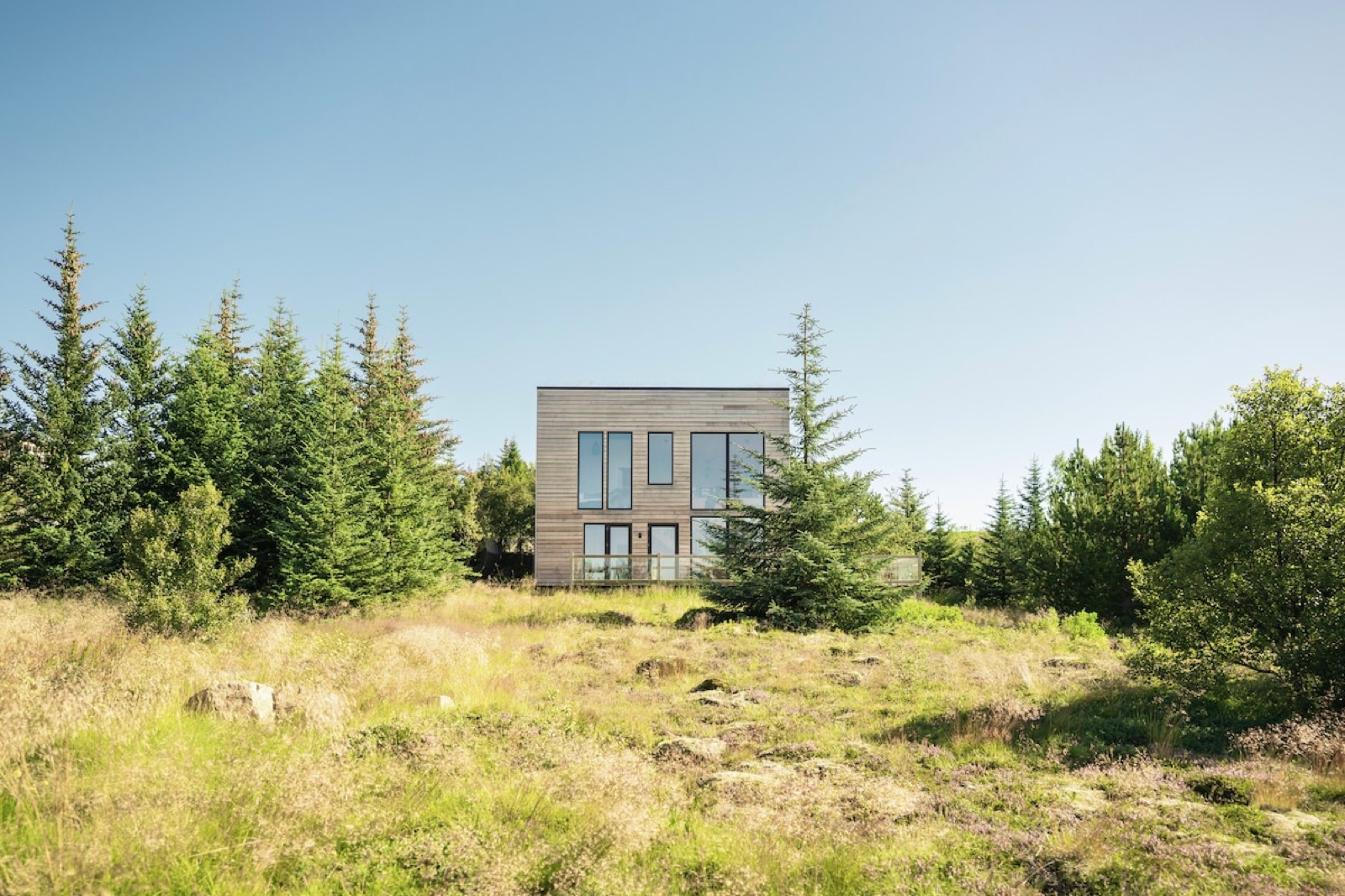 The two storey timber villa standing in summer scrub and spruce