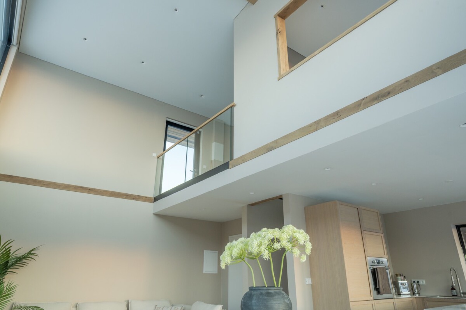 The double-height void, mezzanine balustrade above the kitchen