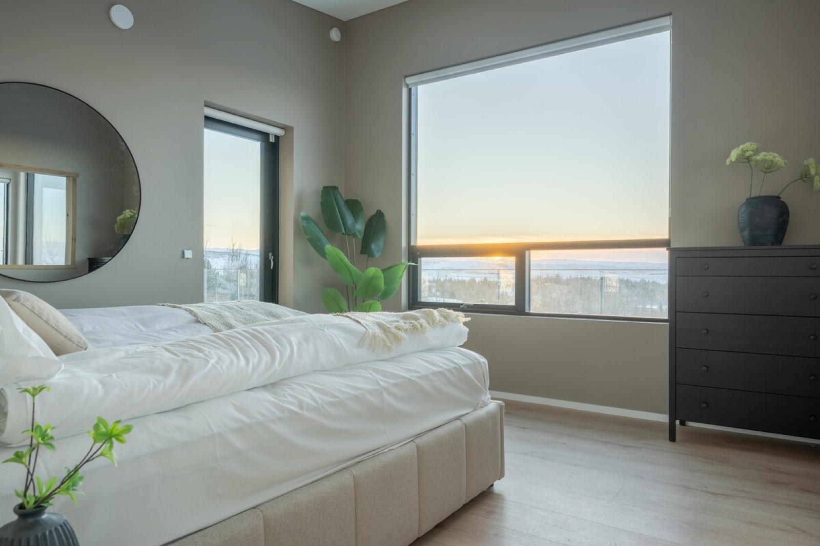 A bedroom at dusk, the last light along the horizon through the window